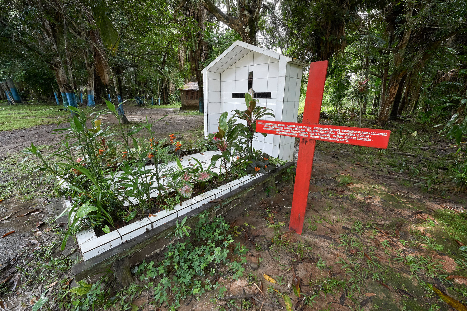 A red cross stands beside the grave of U.S.-born Sister Dorothy Stang in Anapu, Brazil. Sister Stang was assassinated in 2005. The red cross beside her grave bears the names of 16 local rights activists murdered since her killing. Church activists say the killings continue, and by April 2019 they were about to erect a second red cross with even more names.